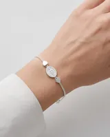 Pulsera de acero con baño de plata, con dije central ovalado de la Virgen Milagrosa y dos pequeños dijes en forma de corazón a los costados.