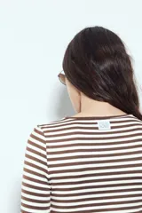 Remera de manga larga con diseño de rayas horizontales en color verde y blanco, de calce ajustado al cuerpo y cuello redondo.