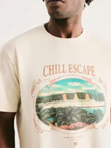 Camiseta de corte regular color azul marino, con cuello redondo y estampa pequeña en el pecho que muestra un paisaje costero.