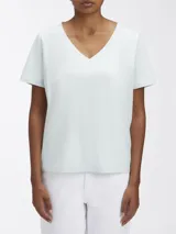 Remera Calvin Klein de manga corta y cuello en V, color verde menta pálido. Presenta una etiqueta con el logo de la marca en la parte posterior del cuello.