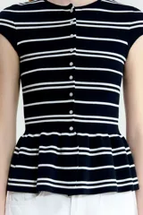 Saco ajustado en punto fino suave, color negro con rayas horizontales blancas. Modelo con cuello redondo, manga japonesa, botones hasta la cintura y peplum acampanado.