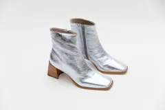 Botas plateadas de cuero con caña media, cierre lateral con cremallera, punta cuadrada y tacón geométrico de madera.