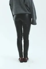 Pantalón skinny de tiro alto confeccionado en ecocuero con textura croco y cierre metálico lateral.