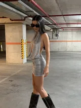 Vestido corto gris melange, con escote halter profundo y corte ajustado.