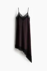 Vestido midi de punto interlock con ribete de encaje negro en el escote y bajo asimétrico. Tiene breteles spaghetti y escote en V.