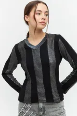 Blusa de punto color beige con escote en V, manga larga y diseño de textura con cortes verticales.
