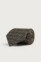 Corbata ancha de seda color marrón oscuro con estampado de raquetas de tenis y volantes. Confeccionada en tejido jacquard con forro de seda.