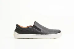 Championes slip-on de cuero negro con textura granulada, diseño barefoot y suela blanca plana.