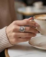 Anillo de plata 925 con diseño circular labrado y cristal central. Presenta un estilo étnico con detalles de puntos en relieve alrededor del centro.
