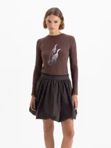 Remera de manga larga color marrón, confeccionada en tejido de punto suave y elástico. Presenta escote redondo a la base y una estampa frontal con diseño de cerezas.