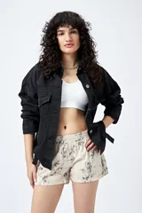 Short color crema con estampado abstracto en tonos grises, de tiro bajo y cintura elástica.