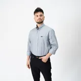 Camisa celeste de manga larga con cuello abotonado y bolsillo en el pecho.