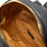 Mochila estructurada compacta de símil gamuza color gris oscuro, con doble asa corta superior y correas traseras regulables. Presenta herrajes metálicos dorados y el logo "XL Extra Large" en dorado en el frente. Cuenta con un compartimento principal con cierre superior y un bolsillo interno con cierre.