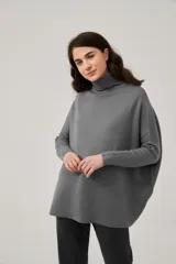 Polera de tejido de punto color gris, de corte holgado, cuello alto y mangas largas ajustadas.