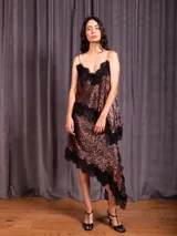 Pollera corta de lentejuelas con diseño asimétrico y terminaciones en puntilla negra. Presenta una cintura elástica para mayor comodidad.