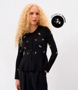 Cardigan negro de punto con bordado floral delicado, mangas largas, escote redondo, cierre frontal con botones y diseño peplum en la cintura.