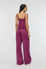 Pantalón de tiro medio con estampa a rayas en tonos fucsia y marrón oscuro, cintura elástica con cordón ajustable, bolsillos laterales y silueta amplia de corte recto.