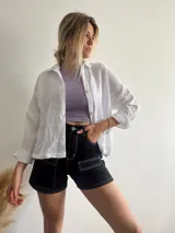 Short de jean negro con bolsillos cargo y costuras blancas contrastantes.