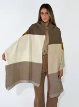 Pashmina de tejido de punto con diseño de bloques de color en tonos tierra, incluyendo marrón, beige y mostaza. Presenta terminaciones acanaladas en los extremos.