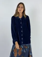 Camisa verde oscuro de terciopelo de viscosa, con cuello mao, corte recto, mangas largas abullonadas y cierre frontal con botones.