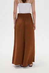 Pantalón ancho de poliéster color marrón, de tiro alto con pinzas en la cintura y punto smock en la parte posterior.