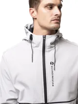 Campera softshell negra con capucha ajustable, cierre frontal completo y bolsillos laterales con cierre. Presenta puños con ajuste de velcro y logo de la marca estampado en el pecho.
