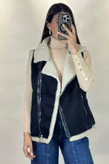 Chaleco tipo gamulán color marrón con interior y bordes de corderito sintético color crema. Presenta cierre frontal y bolsillos laterales con cremalleras metálicas, además de detalles de tiras de cuero sintético.