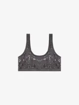 Top bralette color gris oscuro con estampado laminado de aspecto desgastado, escote redondo y banda elástica con logo de la marca.