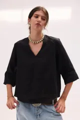 Blusa de lino color lila, de corte relajado y mangas largas amplias, con escote en V y ruedo curvo.