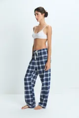 Pantalon de pijama con estampado de cuadros en tonos azul, blanco y rojo, con cintura elástica y corte holgado.