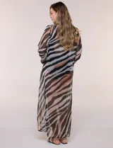 Vestido largo de playa confeccionado en gasa translúcida con estampado animal print en tonos beige, marrón y negro, de corte recto y holgado, con escote en V pronunciado, lazo frontal, mangas largas amplias con puños elastizados y tajos laterales en el ruedo.