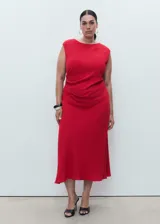 Vestido midi de poliéster color rojo, sin mangas, con cuello redondo y tirantes anchos. Cuenta con diseño entallado, fruncido lateral, forro interior y cierre de cremallera en la parte posterior.