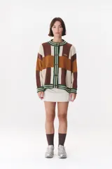 Cardigan de punto con diseño de bloques de color en tonos marrón, beige y verde. Presenta cuello redondo, cierre frontal con botones, mangas largas con hombros caídos y logo bordado en el frente.