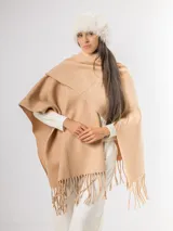 Ruana gris de tejido de punto con flecos en el ruedo.