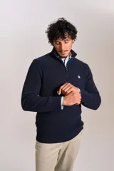 Sweater de punto acanalado color azul marino, con cuello alto y cierre frontal parcial. Presenta el logo de la marca bordado en el pecho y puños con terminación elástica.