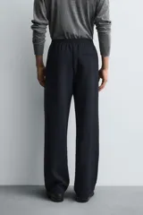 Pantalón relaxed fit color azul marino, confeccionado en tejido fluido con viscosa. Cuenta con cintura elástica ajustable con cordón interior, bolsillos laterales y bolsillos traseros de vivo. Las perneras tienen costura frontal y el bajo es ajustable con cremalleras laterales.