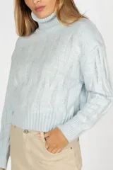 Sweater negro de tejido de punto con cuello alto y mangas largas.