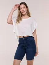 Bermuda de jean azul oscuro con calce ajustado y tecnología push up. Presenta cintura con presillas, cierre frontal con botón metálico, diseño clásico de cinco bolsillos y largo por encima de la rodilla con dobladillo en el ruedo.