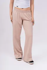 Pantalón de jogging de corte recto y tiro alto, color beige, con cintura elástica y logo bordado pequeño en la parte superior.