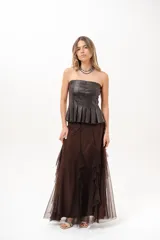 Pollera larga color marrón chocolate, confeccionada en tejido translúcido con múltiples capas y volados en cascada.