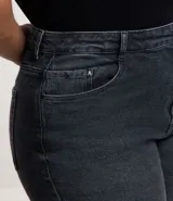 Pantalón de jean negro, modelo recto, con aberturas en el bajo de las piernas. Presenta cintura con elástico y botón mate.