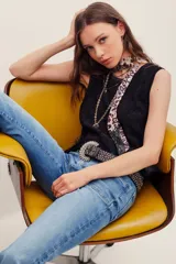 Musculosa negra de encaje con cuello redondo y diseño sin mangas, de corte holgado.