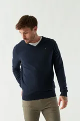 Sweater de punto color rosa con cuello en V y logo bordado en el pecho.