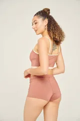 Top tankini color ladrillo con breteles finos ajustables y contorno en color crema.