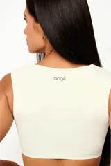 Top deportivo de entrenamiento con escote redondeado y espalda tipo nadador, confeccionado en poliamida tecnológica de alto rendimiento. Cuenta con forro interno y abertura para colocar almohadillas.