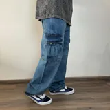 Jean cargo de corte mega oversize en denim azul lavado, con bolsillos laterales tipo cargo y costuras reforzadas.