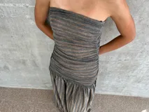Vestido midi con diseño de dos piezas simuladas, cuerpo superior ajustado tipo strapless en lycra y falda inferior fluida en gasa con caída asimétrica.