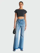 Pantalón de jean Balmain de tiro alto, corte acampanado, bolsillos frontales y traseros, y cierre con botón y cremallera.