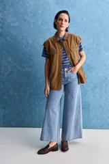 Jean wide leg de tiro alto con calce amplio y pierna ancha, de color celeste con lavado clásico. Presenta diseño de cinco bolsillos y cierre frontal con botón y cremallera.