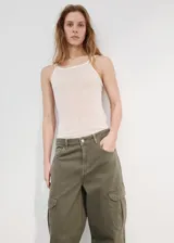 Pantalón cargo de jean color verde militar, de tiro medio, corte ancho y bolsillos laterales con solapa.